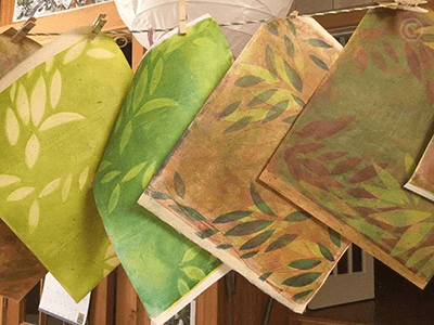 Gelatin printed papers hanging from a line to dry.